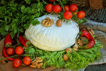 Homemade cheese with tomatoes on a wooden table