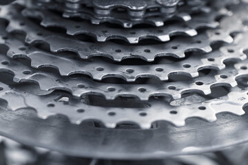 Close-up of a multi-speed bicycle gear with many teeth stained with grease. Spare part bicycle gear for scrolling the chain. Gear wheel in the form of a disk with teeth for high-speed driving.