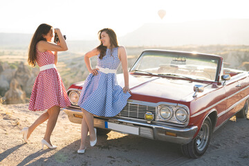 two beautiful girl in a retro dress are photographed on camera  on  mountain landscape in...
