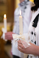 Beautifully burning candle held in hands in the church