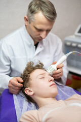 a cosmetologist doctor makes cosmetic procedures on the face of a young guy in a beauty salon