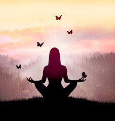 Silhouette of young woman practices yoga and meditates on top of the mountain with night sky, star and butterfly.
