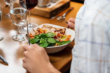 food, people and leisure concept - close up of man with fork eating at restaurant
