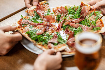 leisure, food and drinks, people and holidays concept - close up of friends eating pizza at...