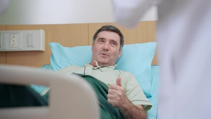 Doctor and nurse checking up body on patient man lying down on medical bed at hospital recovery unit. Caucasian patient admitted in hospital ward get treatment from nurse and doctor at hospital room.