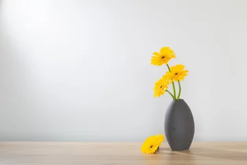 Fotobehang yellow gerbera in  vase on wooden shelf © Maya Kruchancova