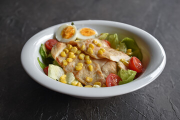 Fresh salad with chicken, egg and lemon. Full of vitamins with fruits and vegetables. Cucumber, quinoa, tomato, orange, corn, onion and avocado