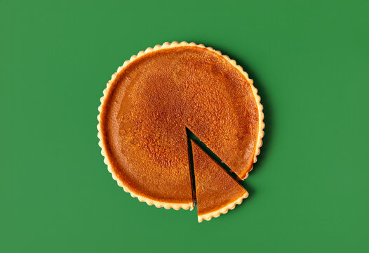 Homemade pumpkin pie isolated on a green background