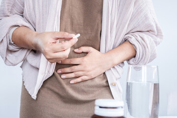 closeup woman hand taking probiotic pill for diarrhea treatment , digestive system problem - obrazy, fototapety, plakaty