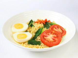 Boiled instant noodles are served in a bowl with a white background