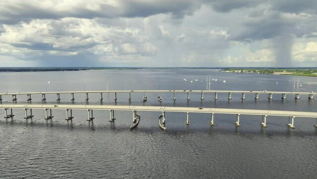 Aerial view of Barron Collier Bridge and Gilchrist Bridge in Florida with moving traffic. Transportation infrastructure in Charlotte County connecting Punta Gorda and Port Charlotte over Peace River