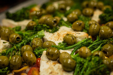 baked healthy vegetarian dish fresh from the oven. Roasted chickpeas, cherry tomatoes, feta cheese, broccoli, and and lemon prepared and ready to eat. delicious tasty wholesome meatless meal