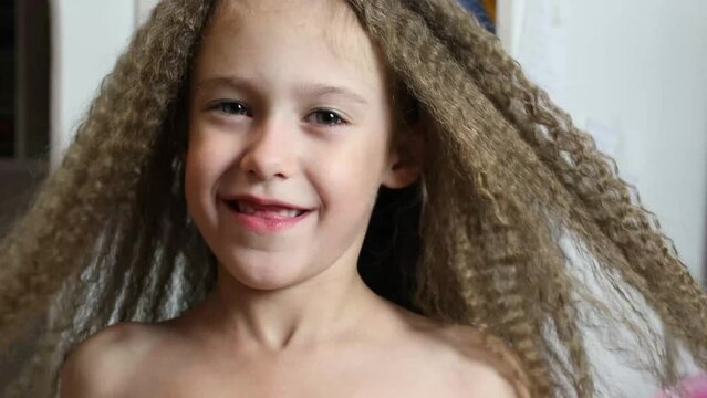 Cute little girl makes faces at the camera. Close-up. Portrait of a 6-year-old rebec