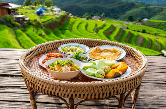 Asian food set in wooden pedestal, Khantoke, wooden utensil used as a small dining food table in northern Thailand and Laos.
