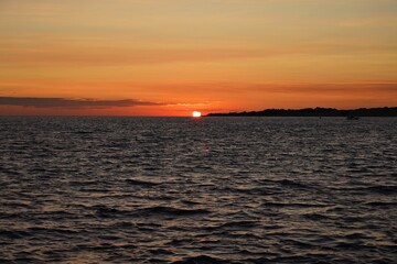 Beautiful colourful sunset on the beach with the sea and waves. A concept for travel, holidays and summer holidays by the sea. Greece - Corfu island - Agios Georgios.