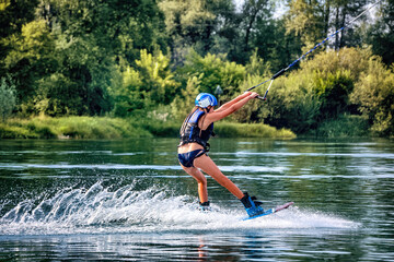 Wakeboarding on the sea on summer day in life jacket. Soft focus. Action blur.