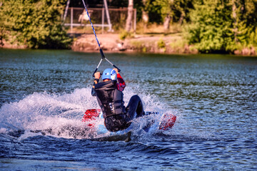 Wakeboarding on the sea on summer day in life jacket. Soft focus. Action blur.