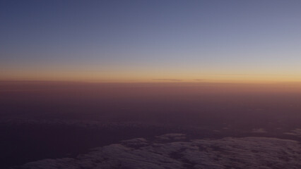 Airplane shot of flying over clouds in sunset