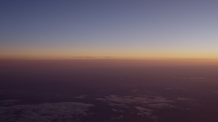 Airplane shot of flying over clouds in sunset