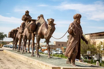 Poster yeah man and multiple camel statue in kiva © oybekostanov