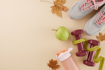 Autumn body sculpting and slimming. Top view flat lay of sneakers, tape measure, dumbbells, plastic bottle, fresh apple, fallen leaves on pastel beige background with commercial placeholder