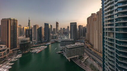 Obraz premium Aerial view to Dubai marina skyscrapers around canal with floating boats all day