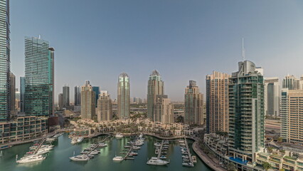 Panorama showing Dubai marina tallest skyscrapers and yachts in harbor aerial.