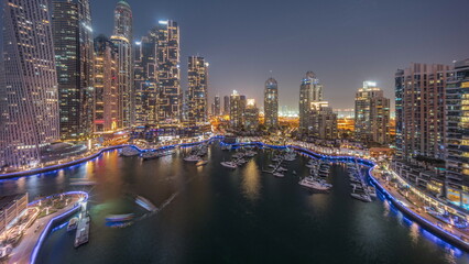 Naklejka premium Dubai marina tallest skyscrapers and yachts in harbor aerial day to night.