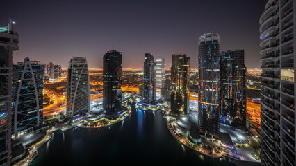 Tall residential buildings at JLT aerial all night, part of the Dubai multi commodities center mixed-use district.