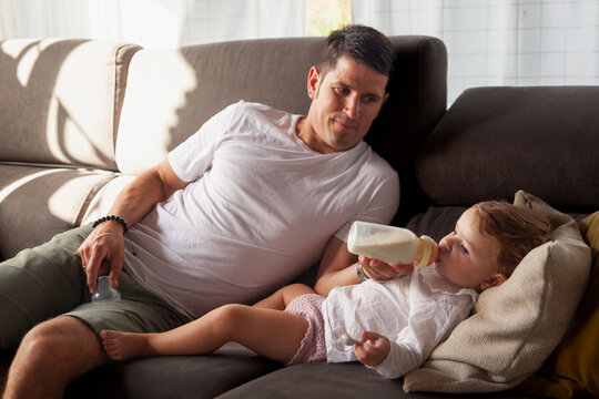 Young father lovingly feeding his baby with a bottle