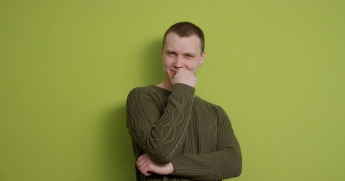 smiling cunning man clasping hands, planning evil tricky prank or scheming, cheating with sly smile studio isolated on green background Gesticulating with fingers planning, scheming prank, having fun