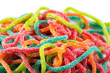 Multicolored jelly candies in the shape of the spaghetti sprinkled with sugar. Close up