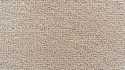 Carpet floor mat or beach towel texture background in sepia beige color made of wool or synthetic fibers, polypropylene, nylon or polyester material