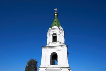 Obraz premium White bell tower of an Orthodox church against a blue sky without clouds