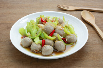 close up of stir fried meatball with banana pepper in a ceramic dish on wooden table. hot and spicy asian homemade style food concept.