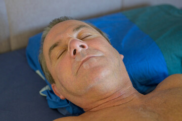 Close up of a sleeping man with a nose tape and a mouth tape