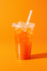 Orange color drink in a plastic cup isolated on a orange color background. Take away drinks concept