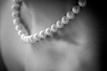 détails d'un collier de perles de culture sur une peau blanche