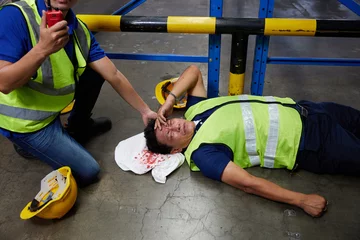 Fotobehang senior worker fell over and his head is bleeding on the floor in the factory © offsuperphoto