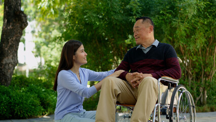 A daughter taking care of the patient in a wheelchair and talk with mom. Concept of happy retirement with care from a caregiver and Savings and senior health insurance, Happy family and retirement
