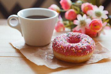 Strawberry donut and coffee cup on the table. Valentine's day concept.