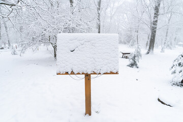 Fototapeta premium Wooden sign board in the snowy park