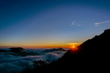 The sun and sea of ​​clouds and hills combine so beautifully under the blue sky in the afternoon before sunset