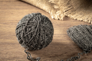 Balls of gray homemade yarn and knitted items lie on the table