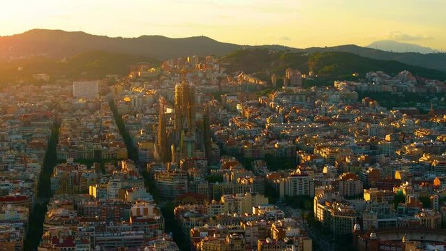 Aerial Shot of Bas&iacute;lica i Temple Expiatori de la Sagrada Fam&iacute;lia At Sunset. Avinguda de Gaud&iacute;, beautiful panorama. European cityscape. Mediterranean city. Aerial establishing shot of Barcelona. 