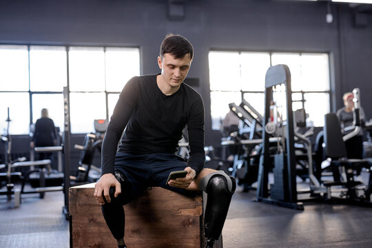 disabled man texting message, sms, surfing net, internet, making phone call looking at screen of phone close up photo. free time spare time active guy with handicapped both leg scrolling in smartphone