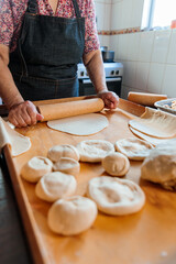 Unrecognizable latin mature woman kneading dough in her countryside home kitchen