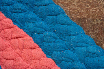 Texture of old carpet that has stain, dust and dirty. It's typically produced by weaving or knitting textile with fiber blue and red colour. It may be accumulate germs spot.
