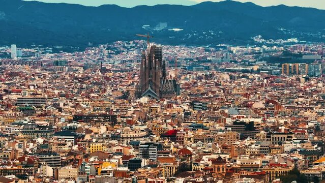 Aerial Shot of Bas&iacute;lica i Temple Expiatori de la Sagrada Fam&iacute;lia At Sunset. Avinguda de Gaud&iacute;, beautiful panorama. European cityscape. Mediterranean city. Aerial establishing shot of Barcelona. 