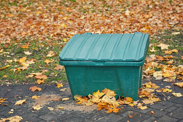 Grit bin, sand and salt mixture for improve traction on snowy and icy pavement. Grit box in autumn park, prepare for winter season. Container with gritting material